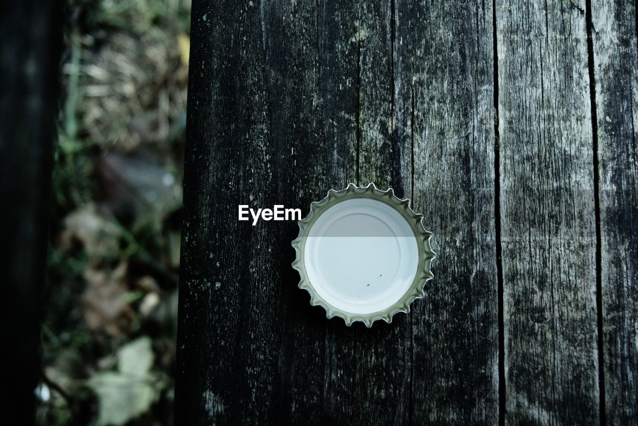 Close-up of metallic bottle cap on wood