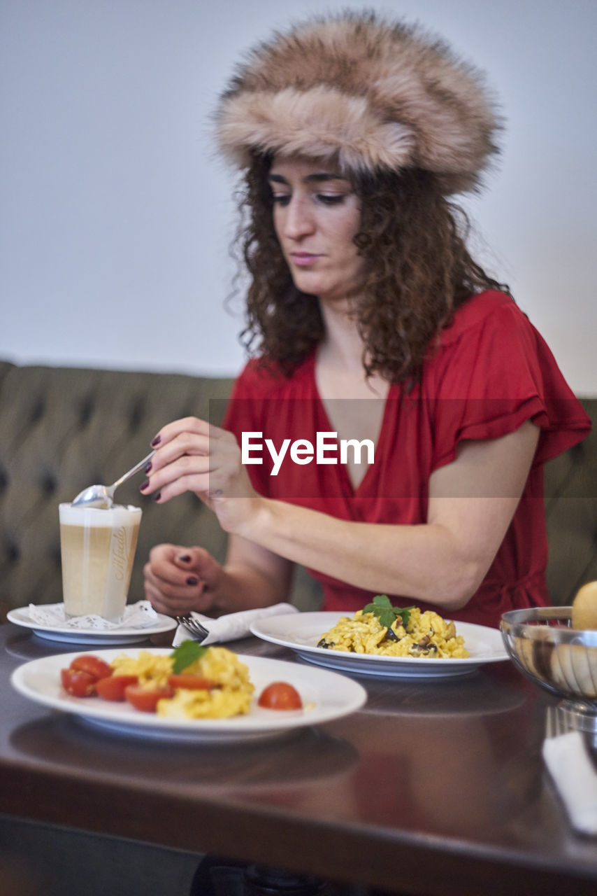 Mature woman sitting with food on table at restaurant