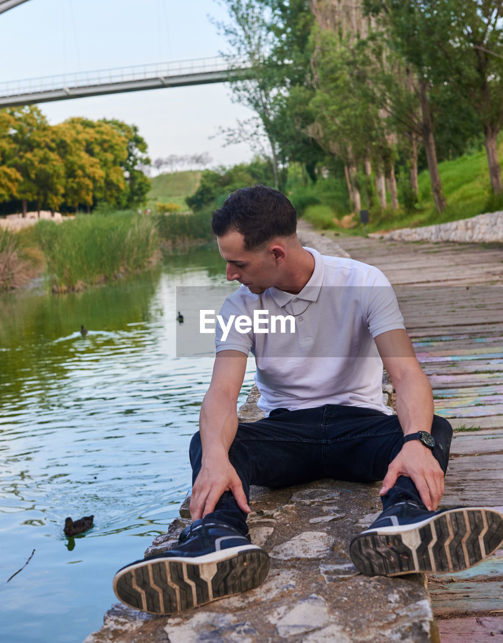 water, one person, men, sitting, nature, adult, full length, casual clothing, lake, day, leisure activity, plant, lifestyles, tree, young adult, outdoors, looking, person, relaxation, clothing, sky