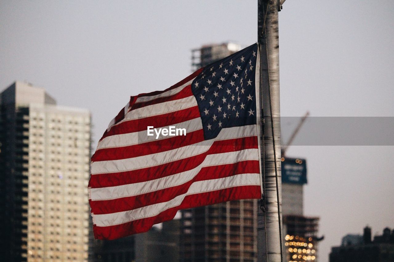Close-up of american flag against buildings in city