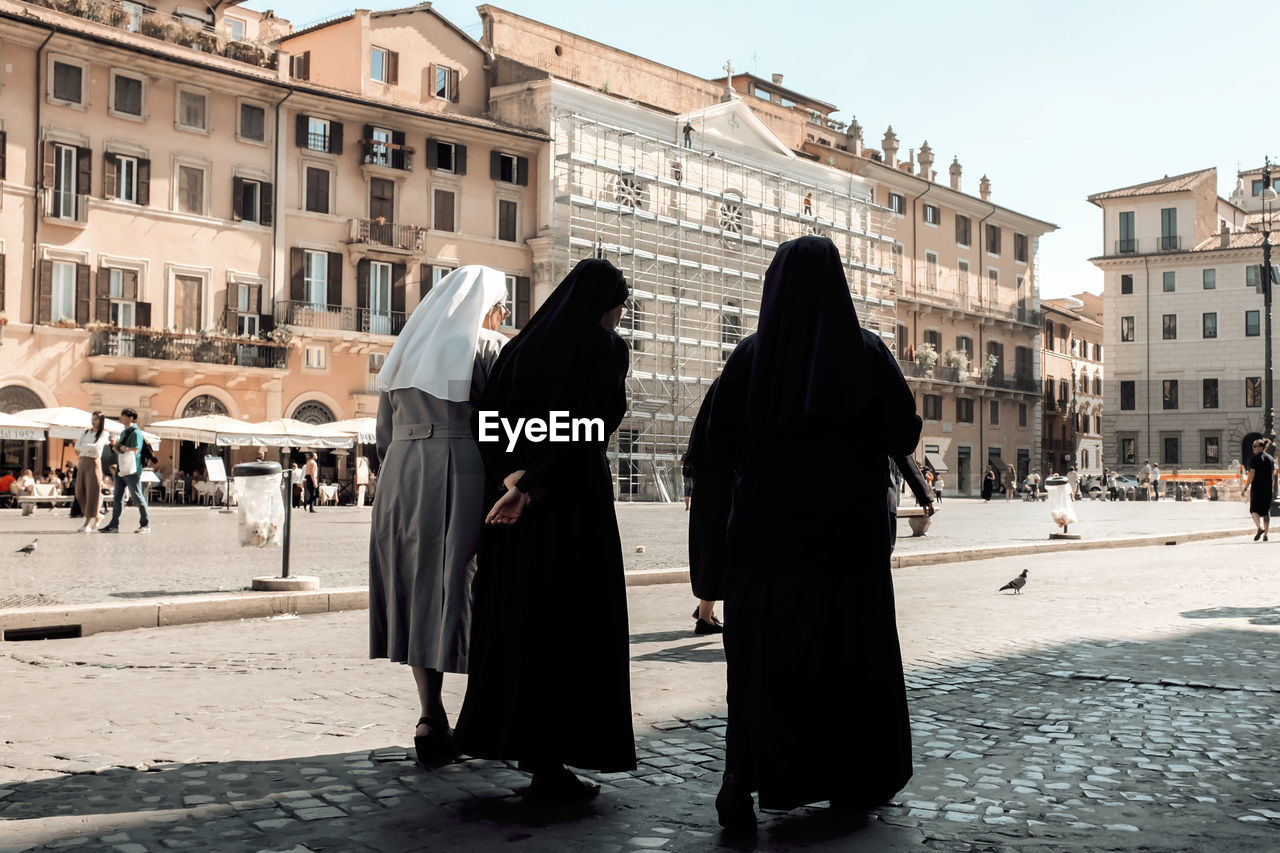 Rear view of nuns walking on street in roma