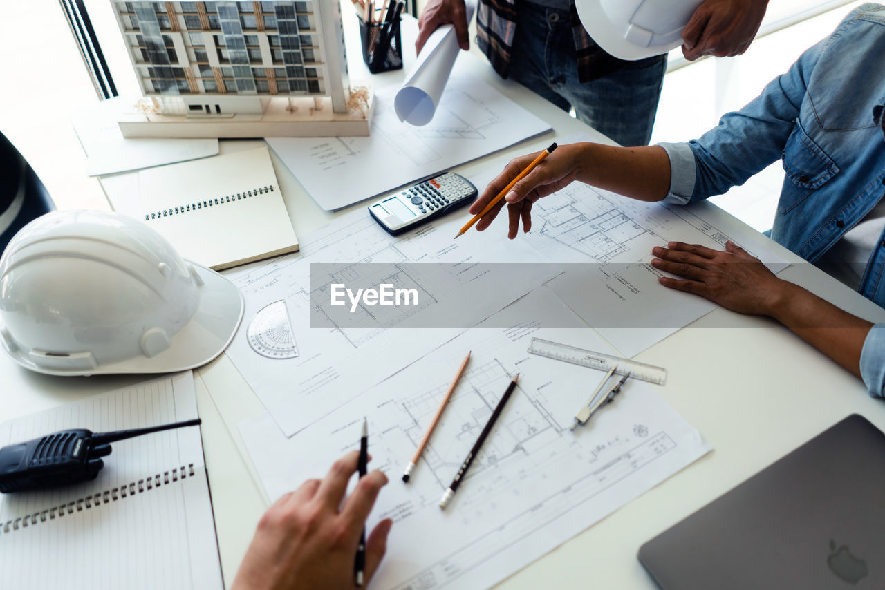 high angle view of business people working on blueprint in office