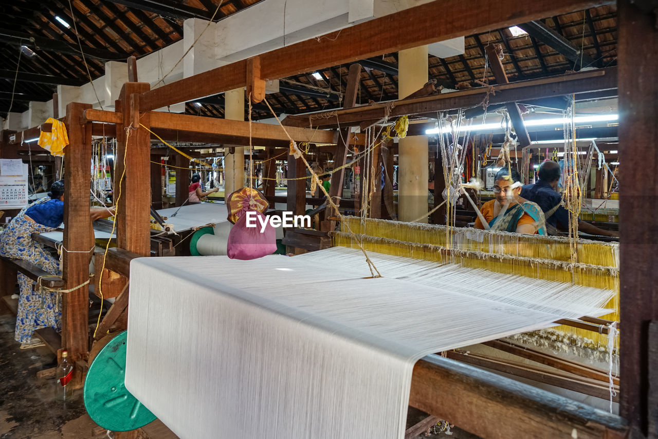 Women work in an old loom weaving cooperative in kannur, kerala, india