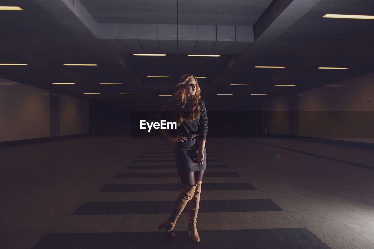 Full length of woman standing in underground walkway