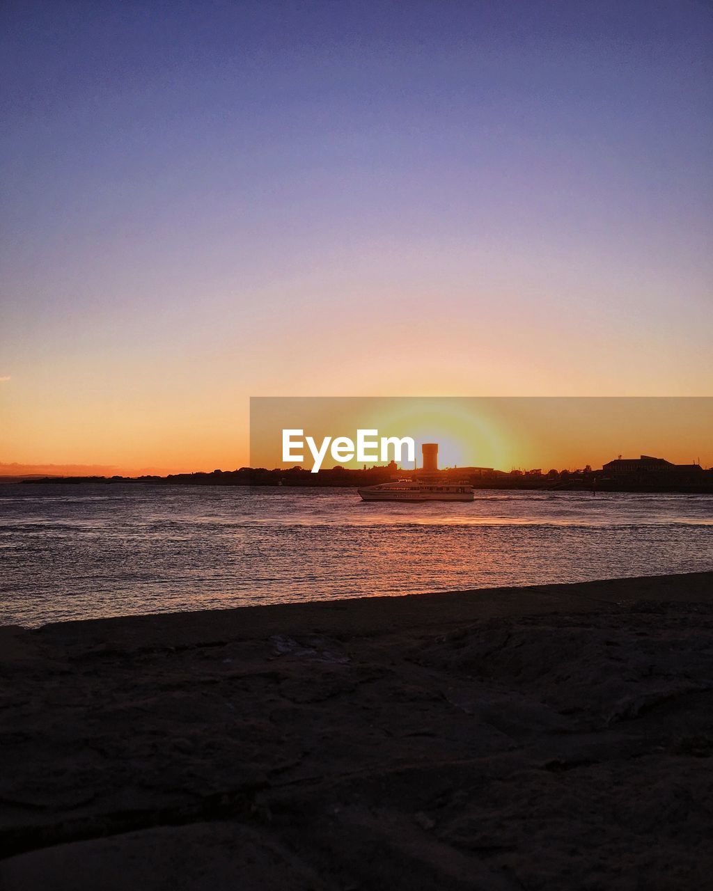 SCENIC VIEW OF BEACH AGAINST CLEAR SKY DURING SUNSET