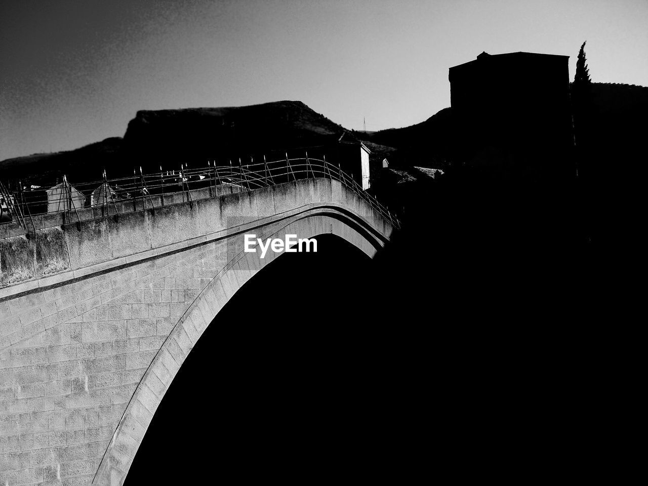 Silhouette bridge against sky in city