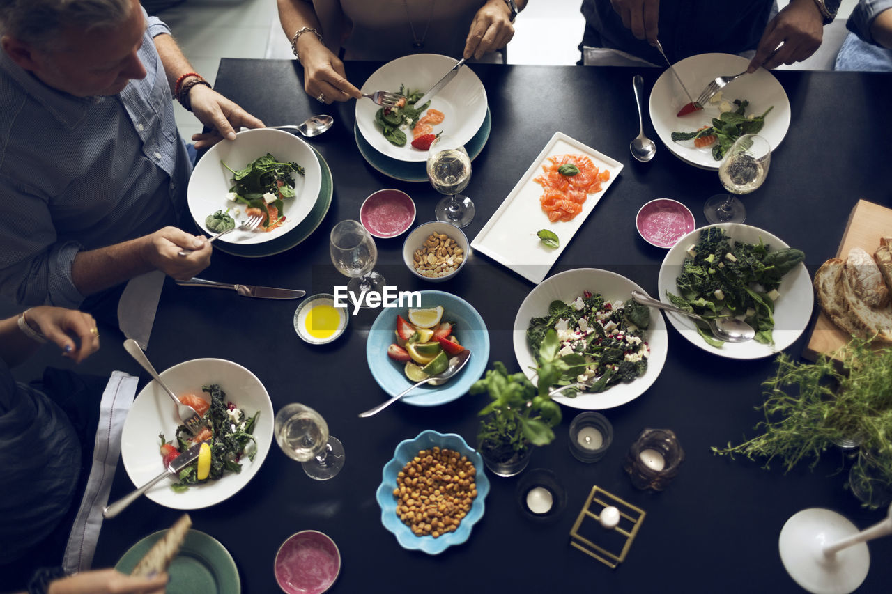 High angle view of multi-ethnic friends eating food at table