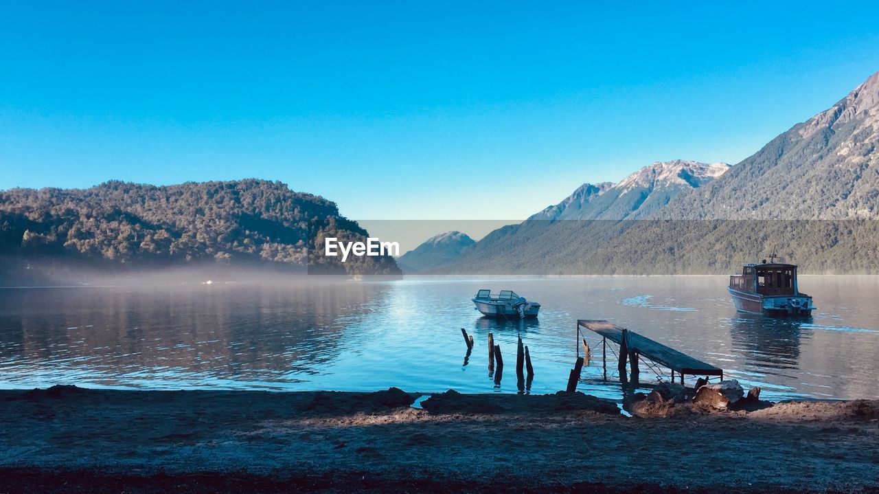 Scenic view of lake against clear blue sky