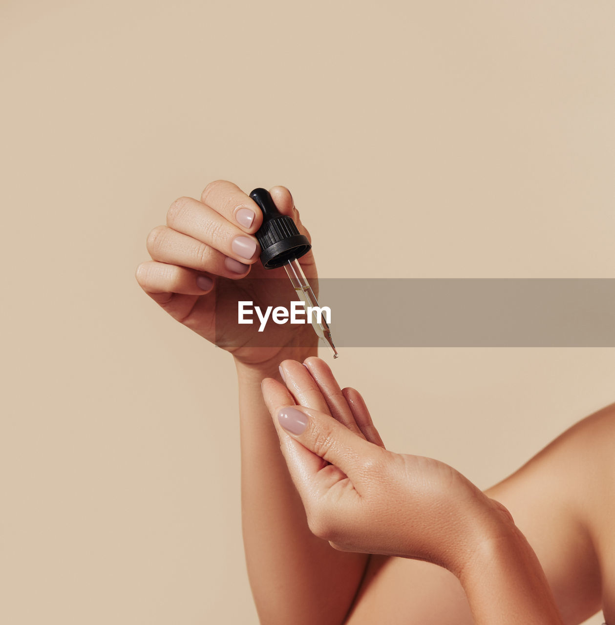 cropped hand of woman holding figurine against pink background