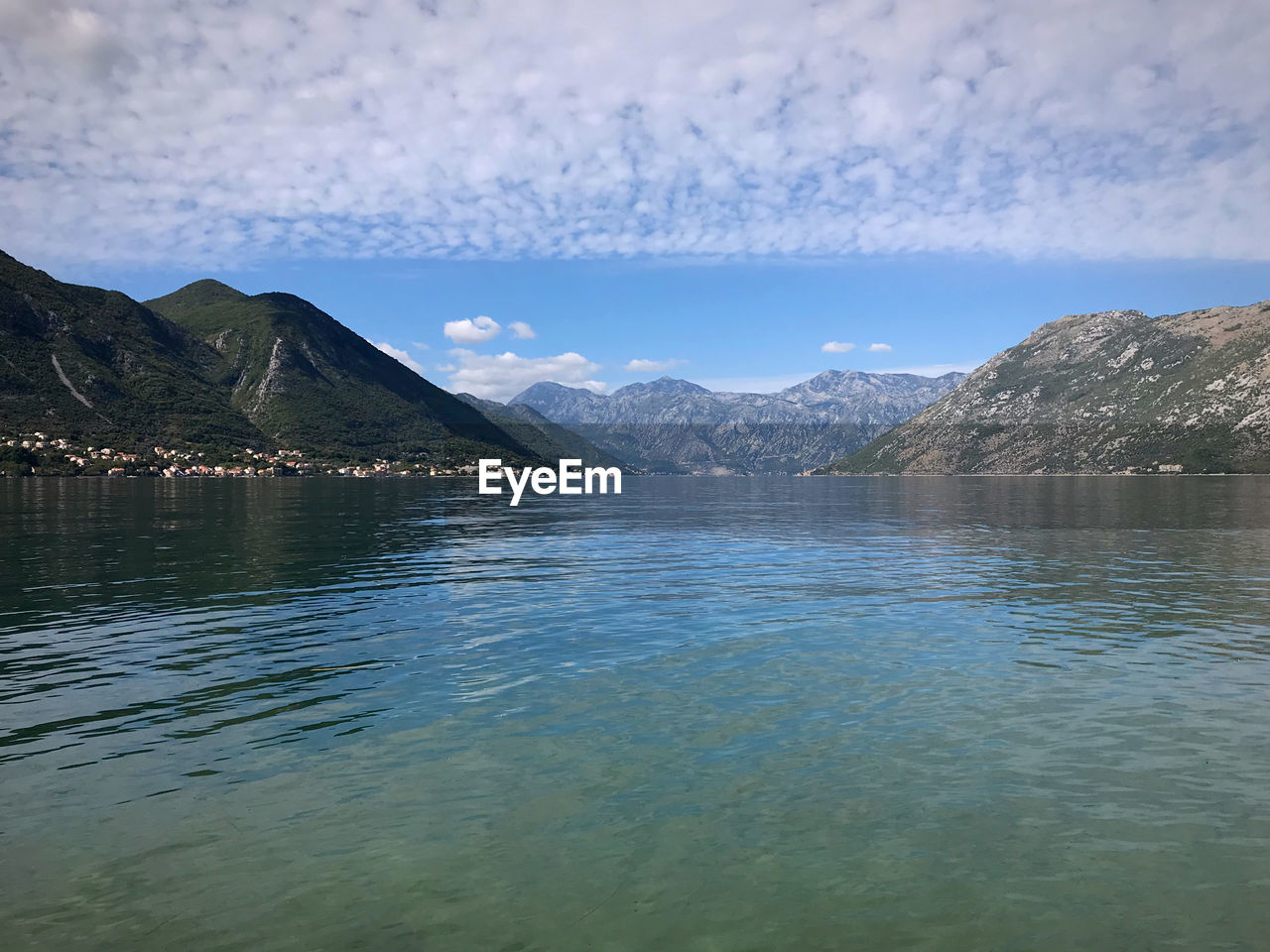 SCENIC VIEW OF LAKE BY MOUNTAIN AGAINST SKY