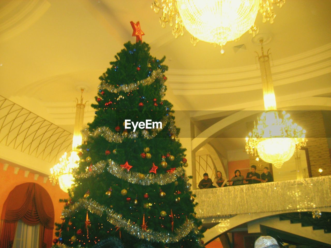 LOW ANGLE VIEW OF ILLUMINATED CHRISTMAS DECORATIONS ON CEILING