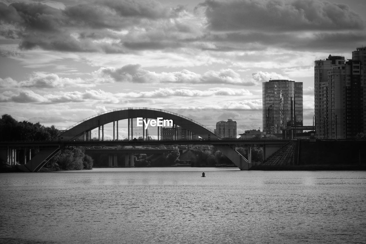 BRIDGE OVER RIVER AGAINST BUILDINGS IN CITY