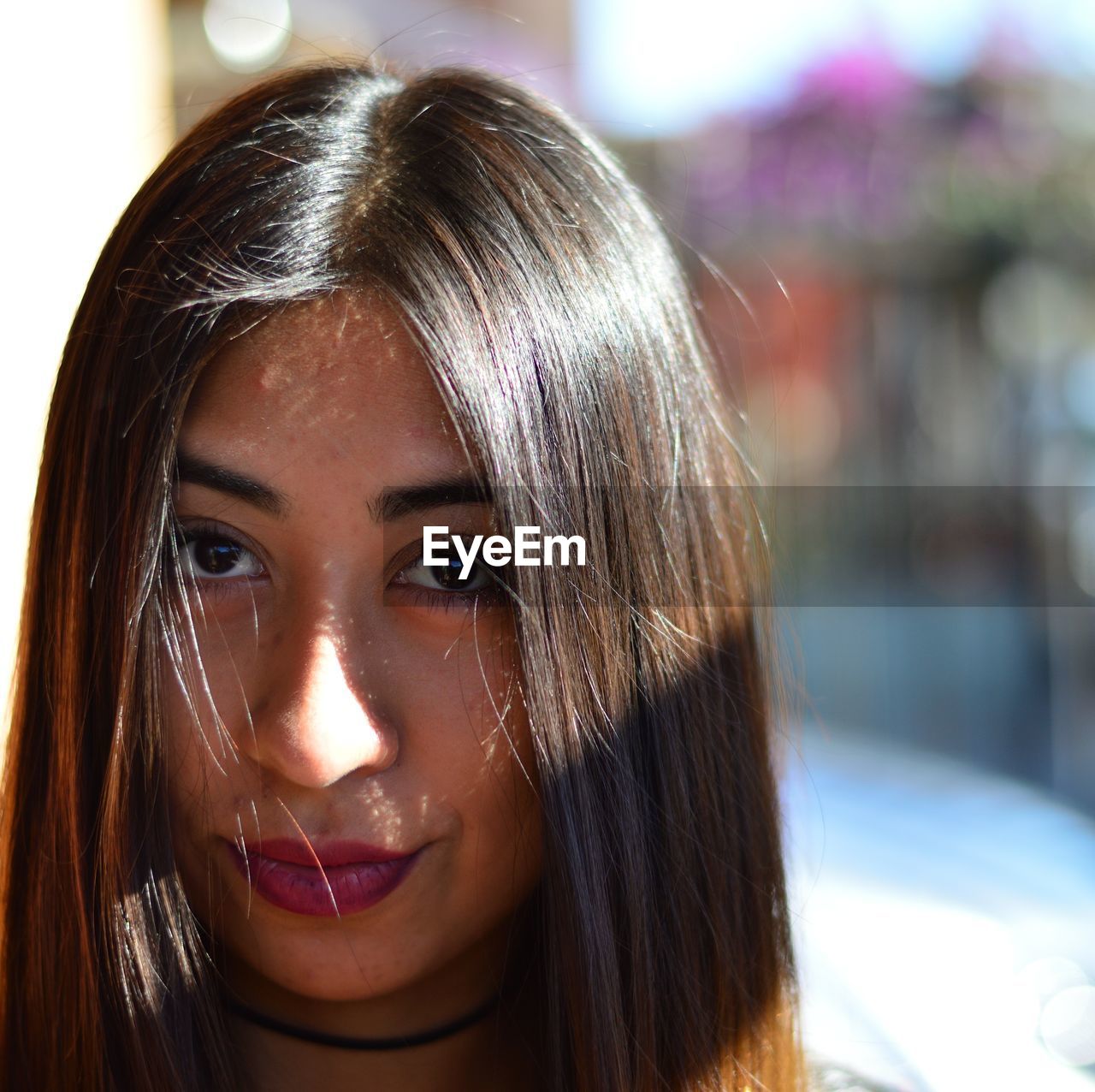 Close-up portrait of young woman during sunny day