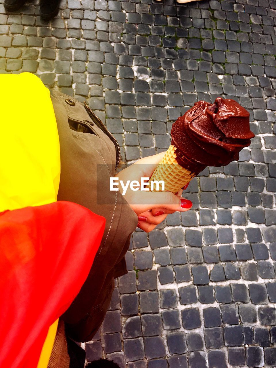 Cropped image of woman holding chocolate ice cream cone