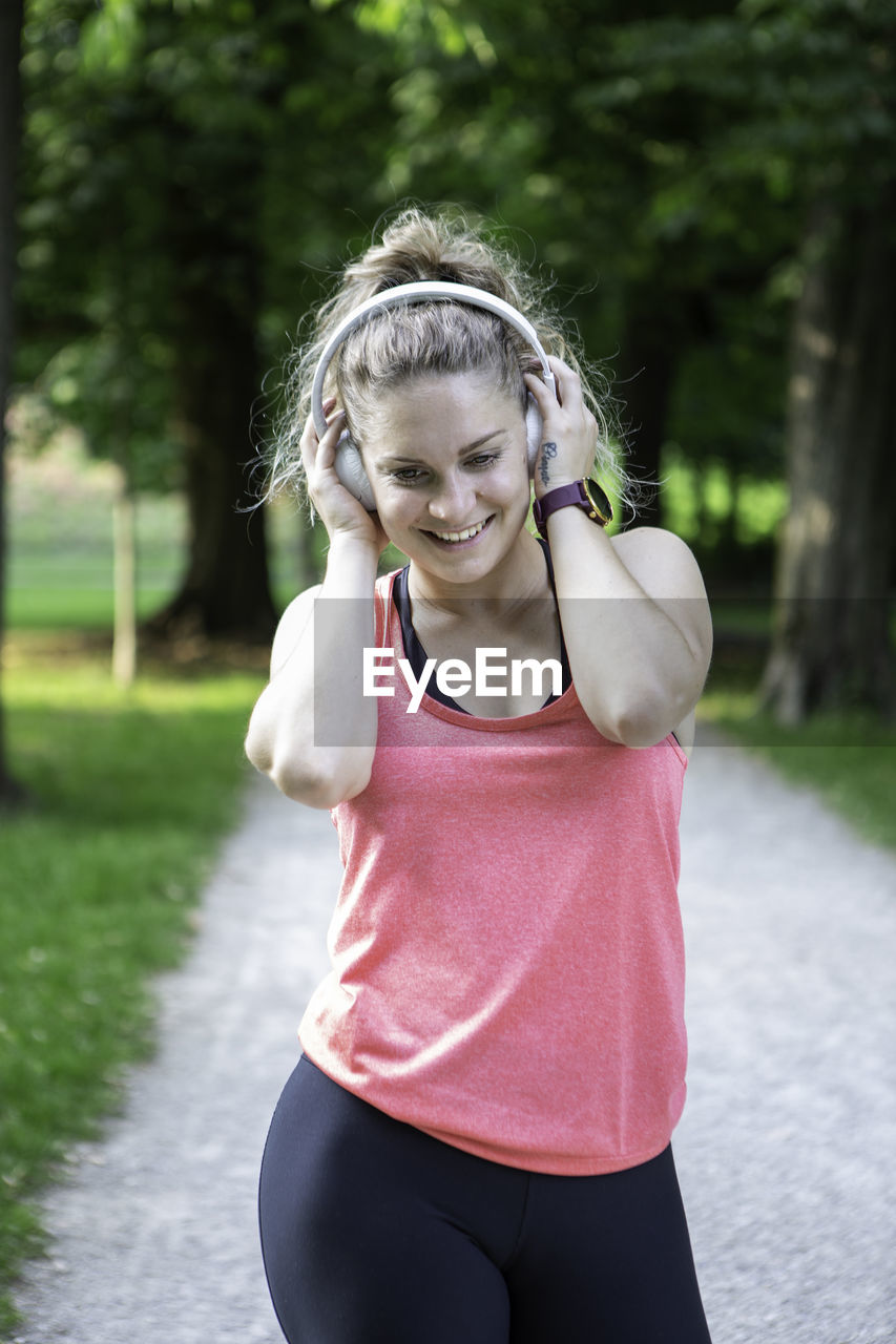 A blond german lady listens to music on her wireless headphones.