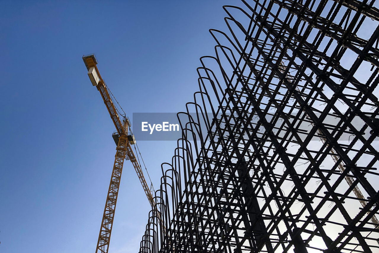 Tower crane and metal reinforcement framework of concrete wall.