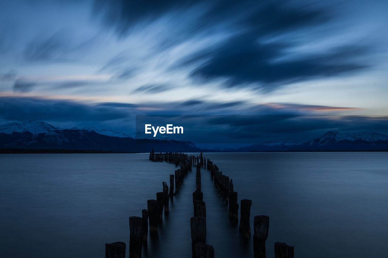 Pier on sea against sky at dusk