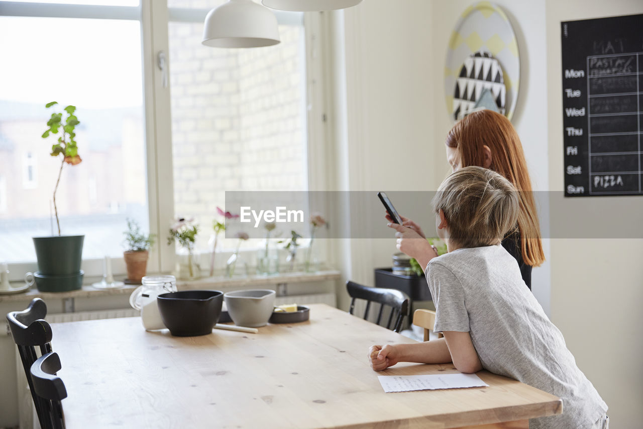 Children using phone while baking