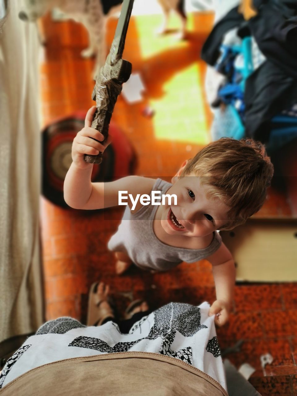 High angle portrait of smiling cute boy standing by mother at home