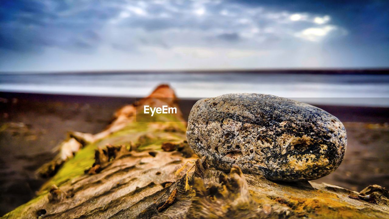 Close-up of rocks on shore against sky