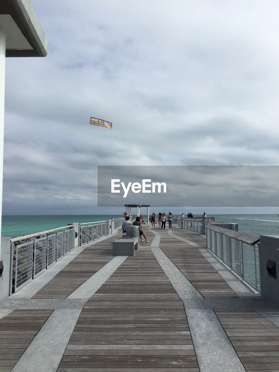 VIEW OF PIER ON SEA AGAINST CLOUDY SKY