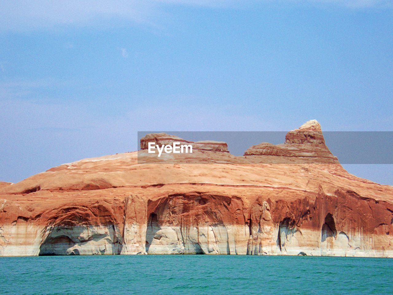 Scenic view of lake powell and rock formations against clear blue sky