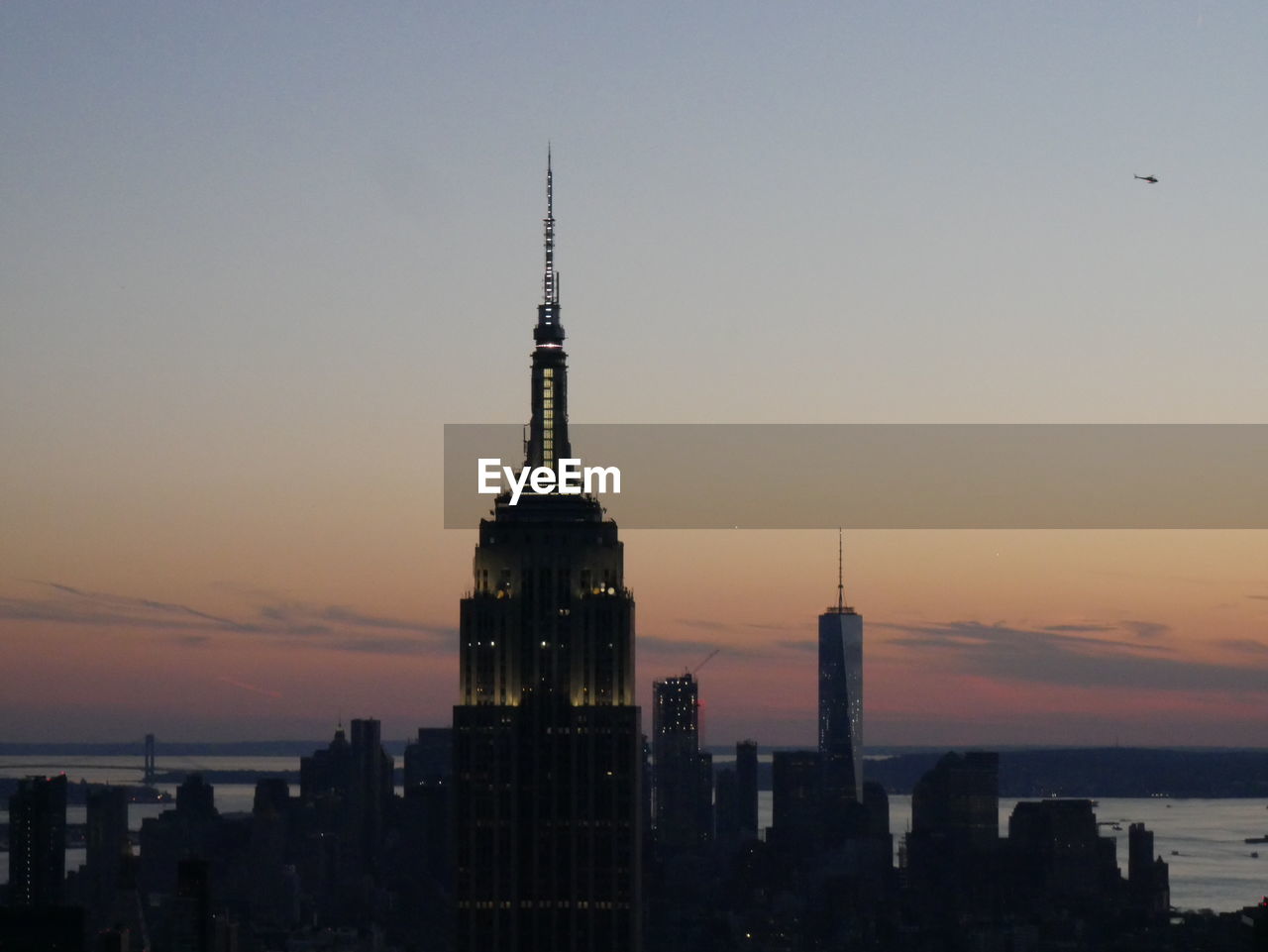 Buildings in city against sky during sunset