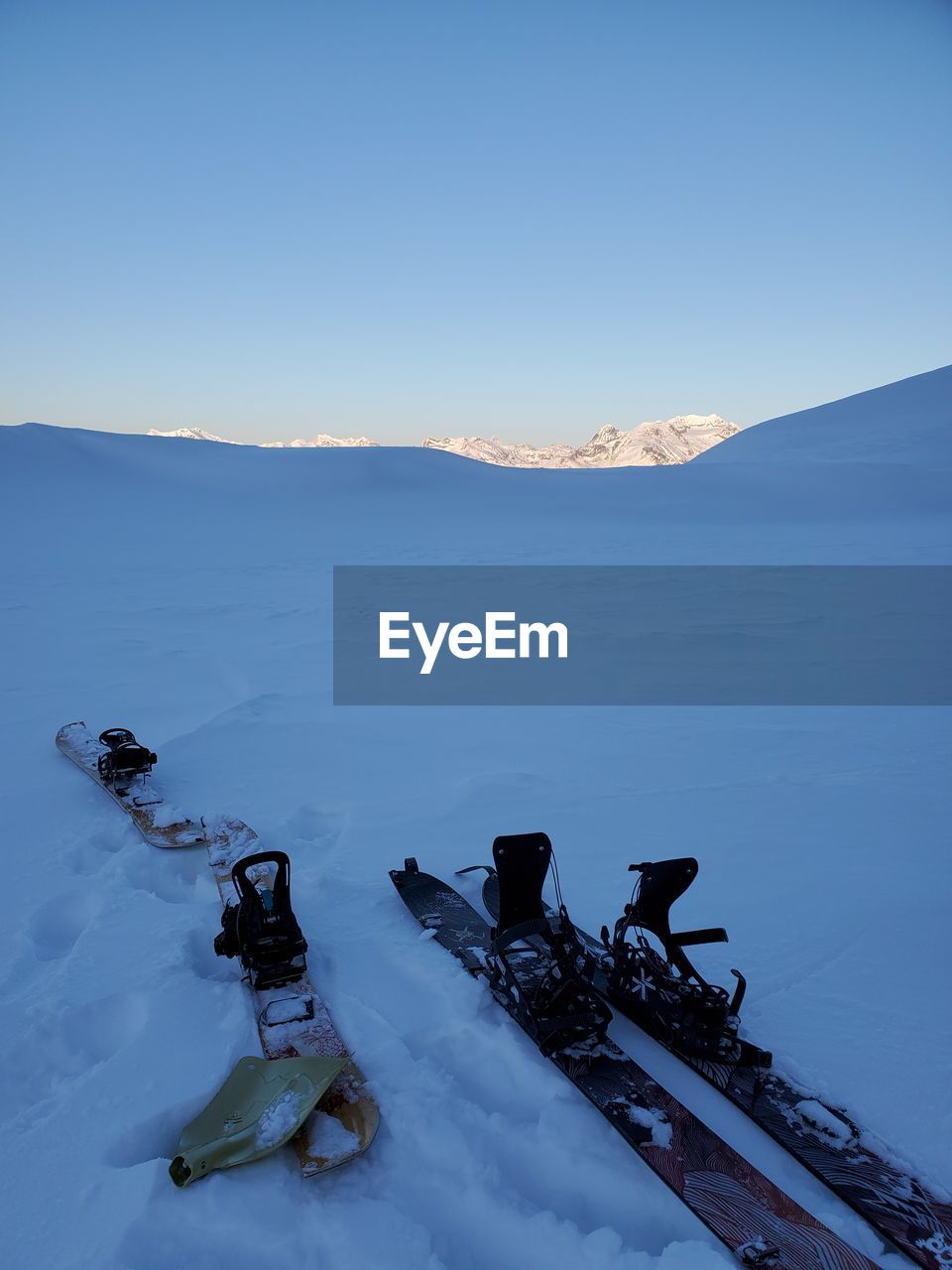 Scenic view of snow covered mountains against clear blue sky