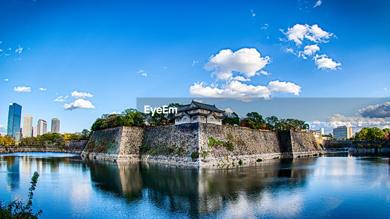 Castle by lake against sky