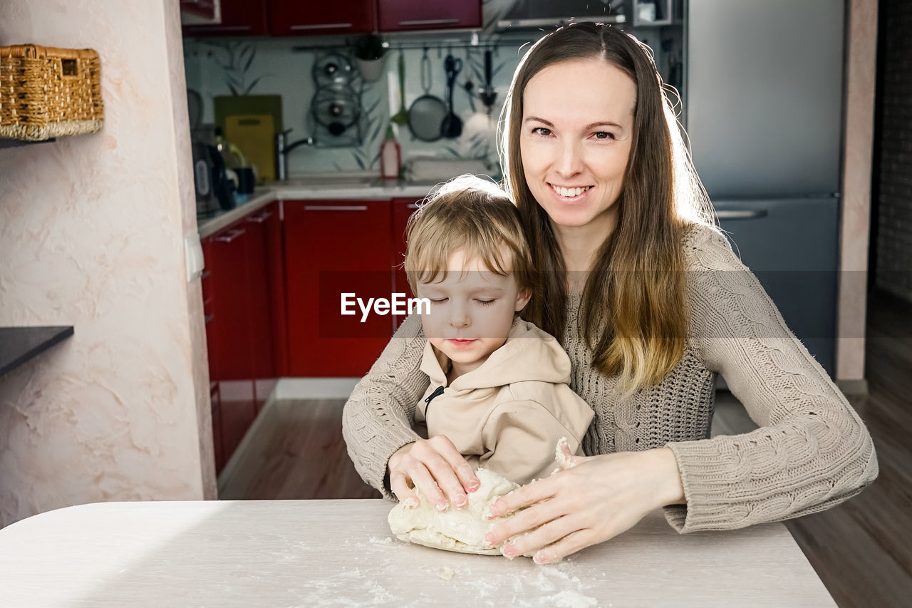 Mother and son preparing food on table