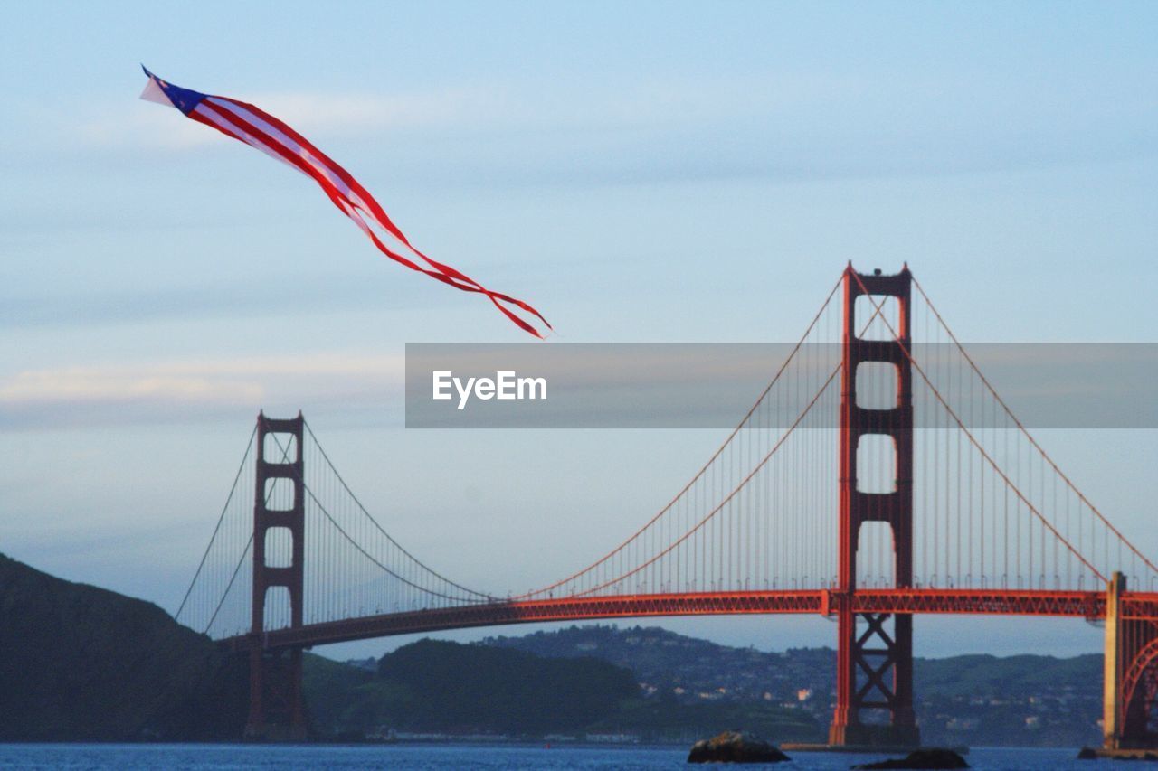 American flag kite flying against golden gate bridge over san francisco bay