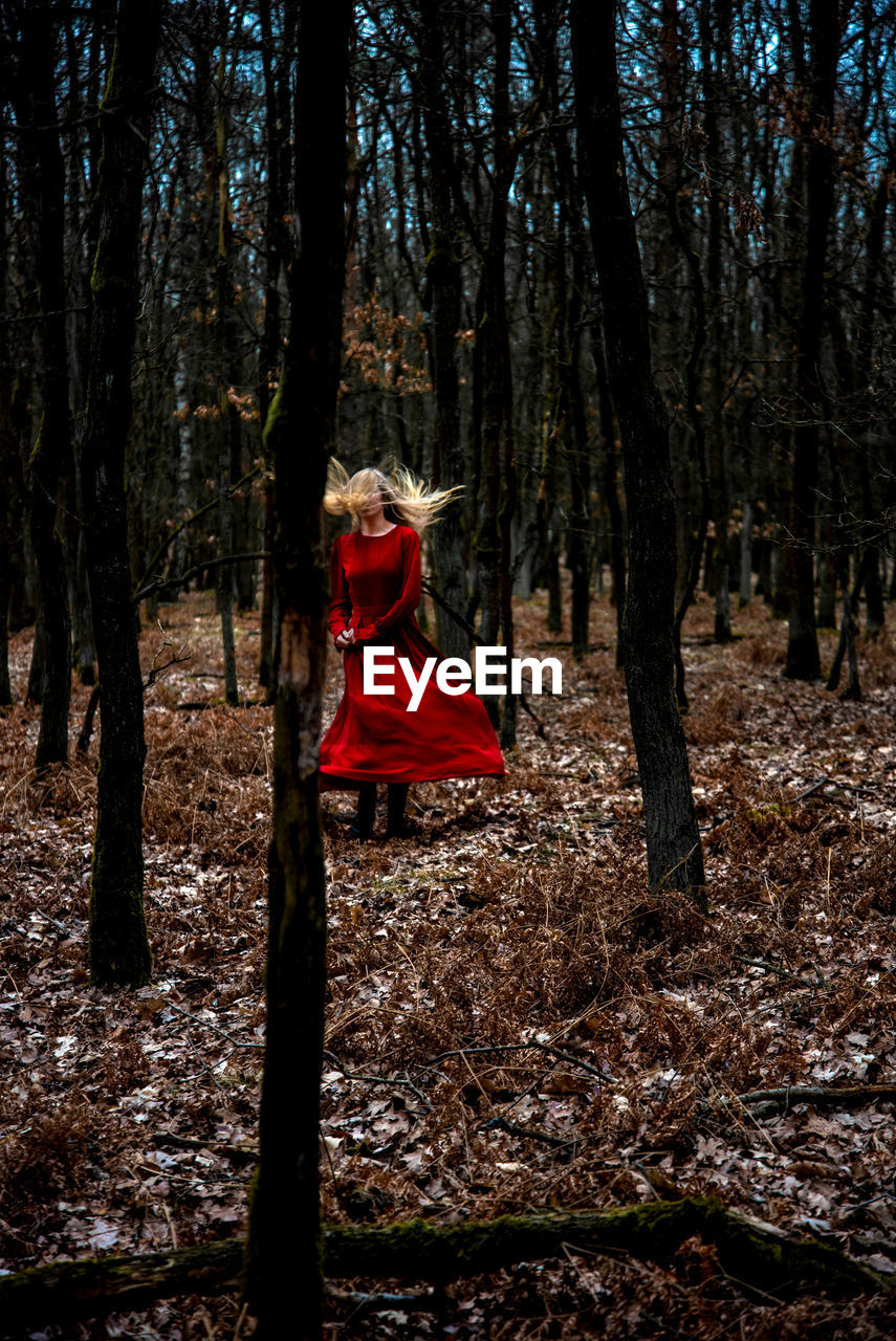 MAN STANDING ON FIELD IN FOREST