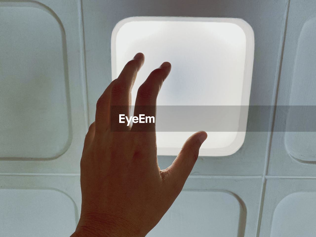 Cropped image of hand against window