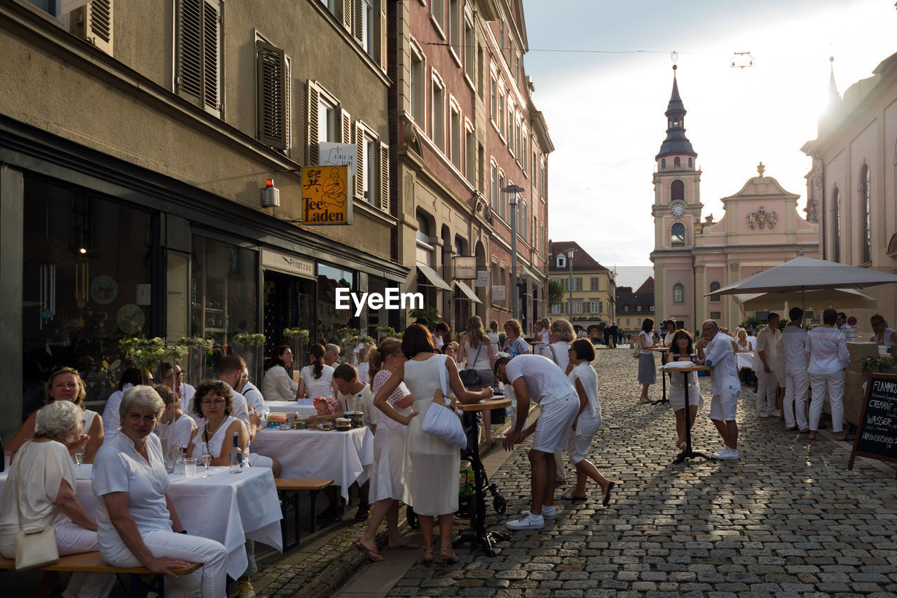 PEOPLE SITTING ON STREET IN CITY