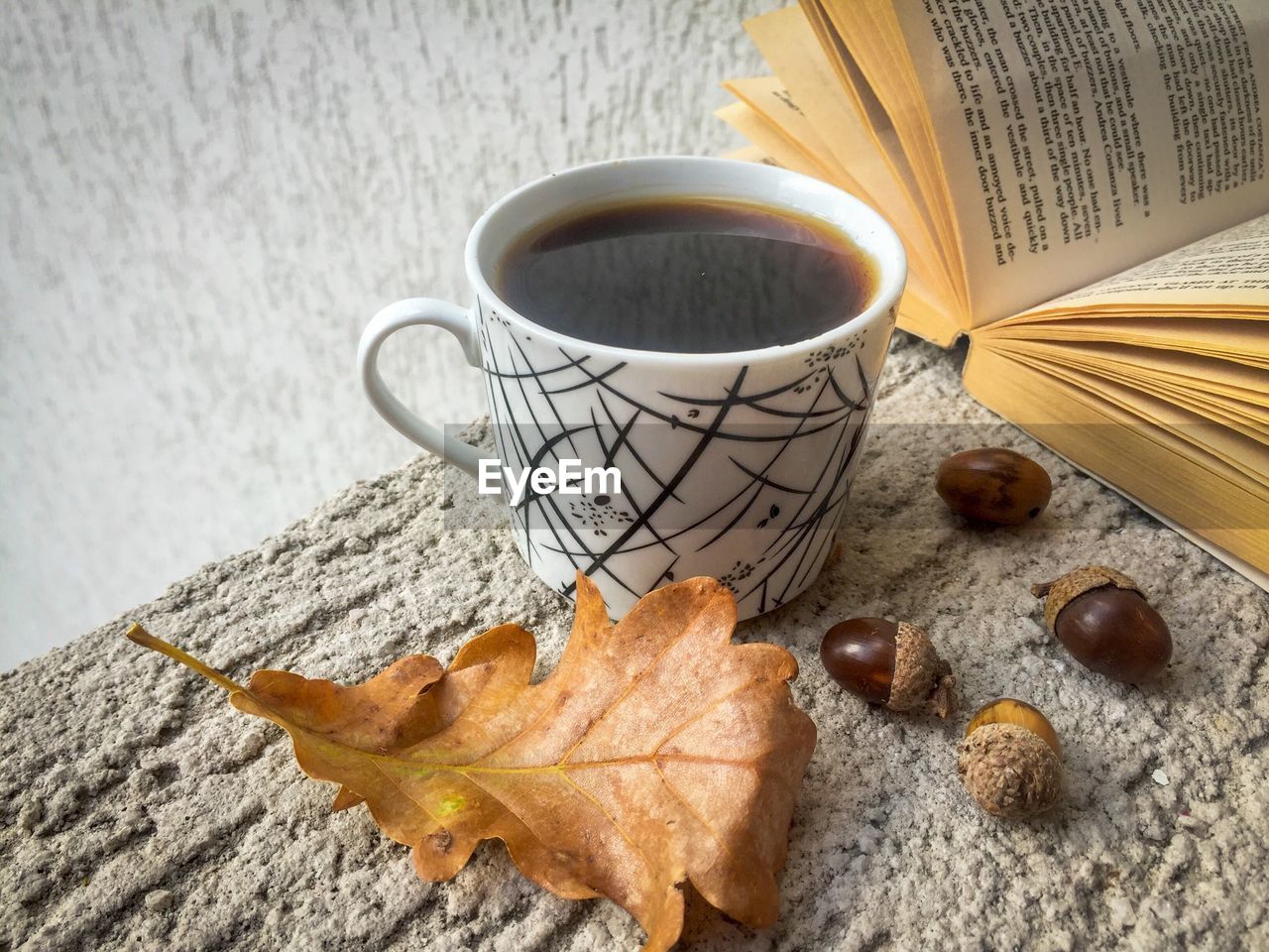 Close-up of coffee with book and leaf