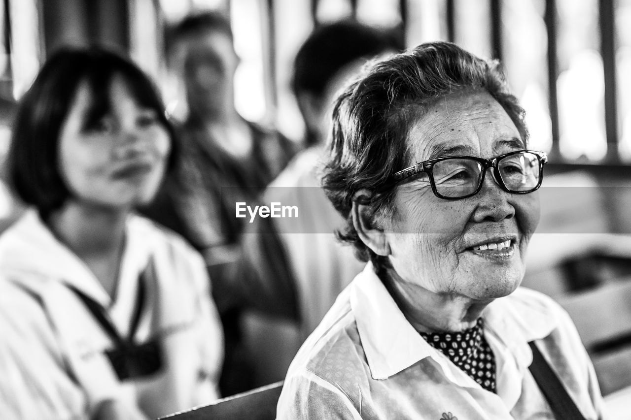 Smiling senior woman wearing eyeglasses looking away