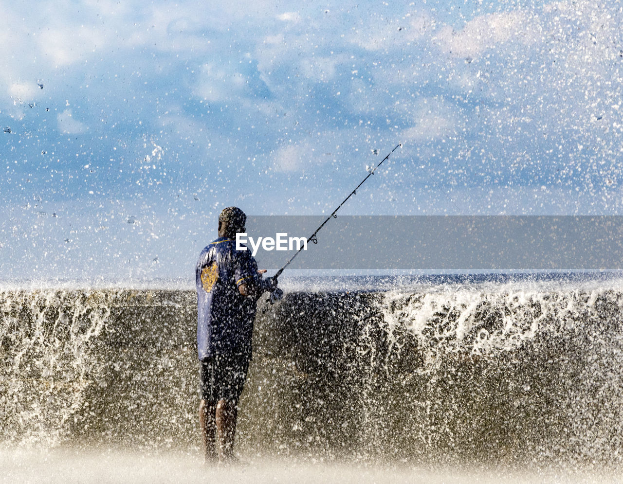 MAN STANDING ON SEA SHORE