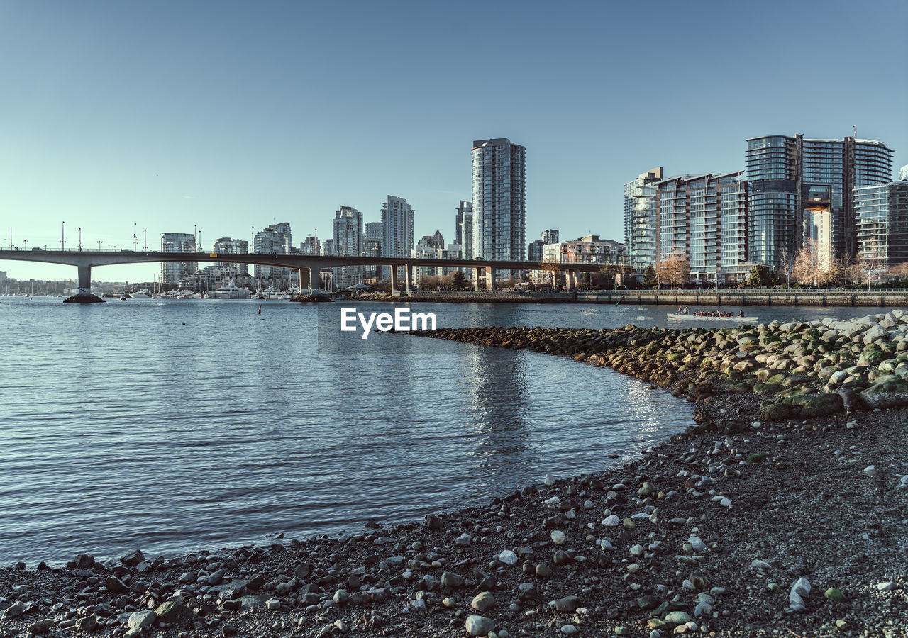 RIVER BY BUILDINGS AGAINST CLEAR SKY IN CITY