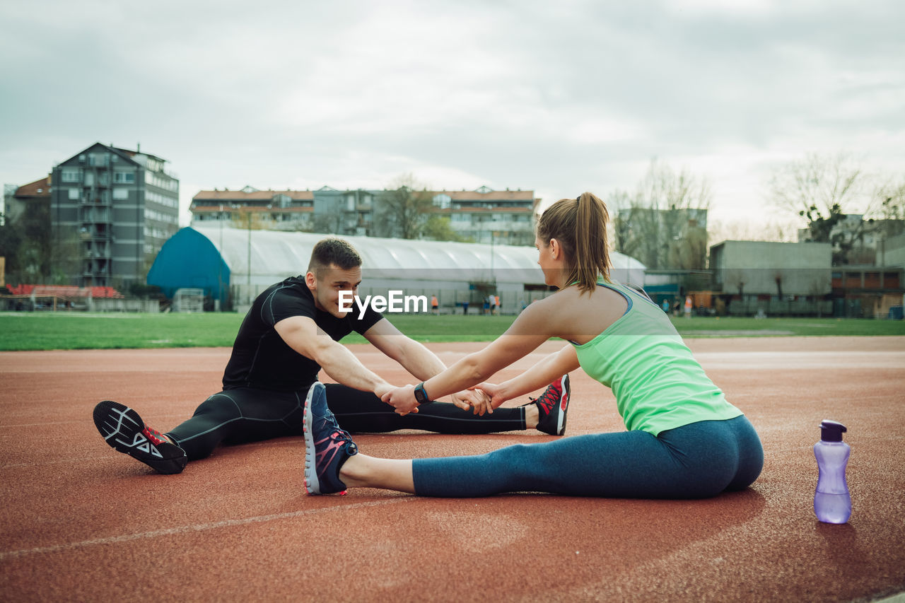 Friends exercising together on sports track