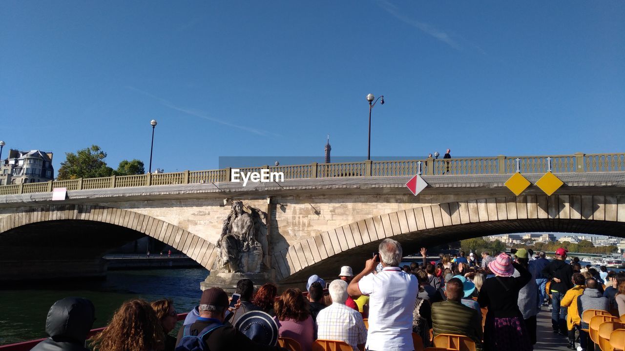 PEOPLE ON BRIDGE AGAINST SKY