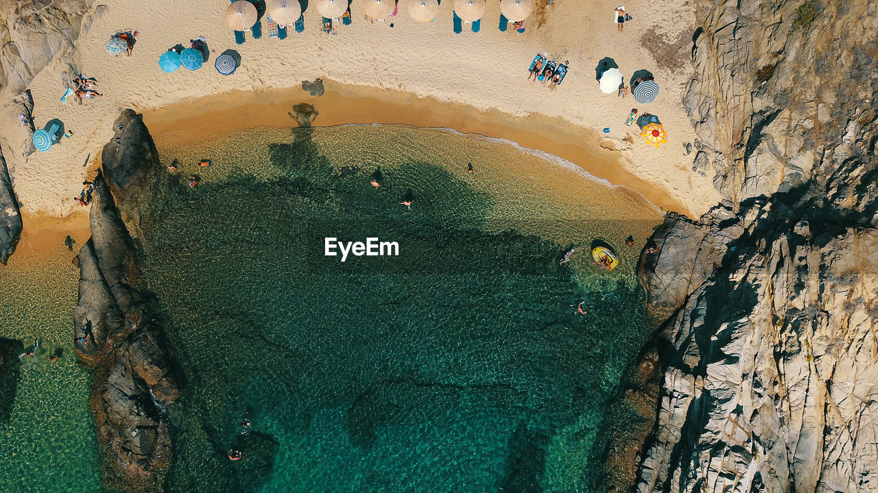 Aerial view of people on beach by rock formation