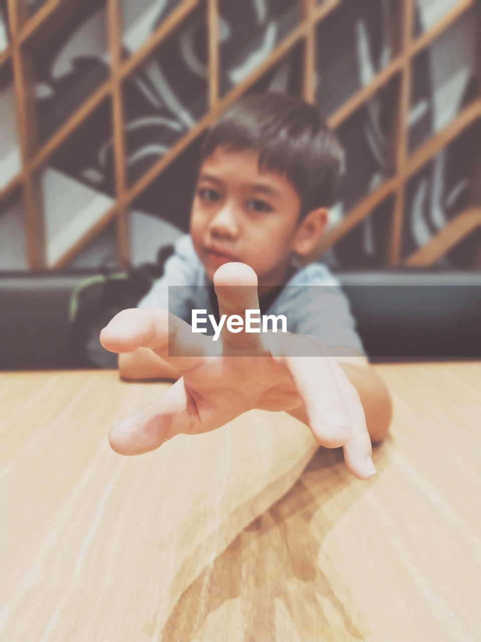 Portrait of boy gesturing at table in restaurant