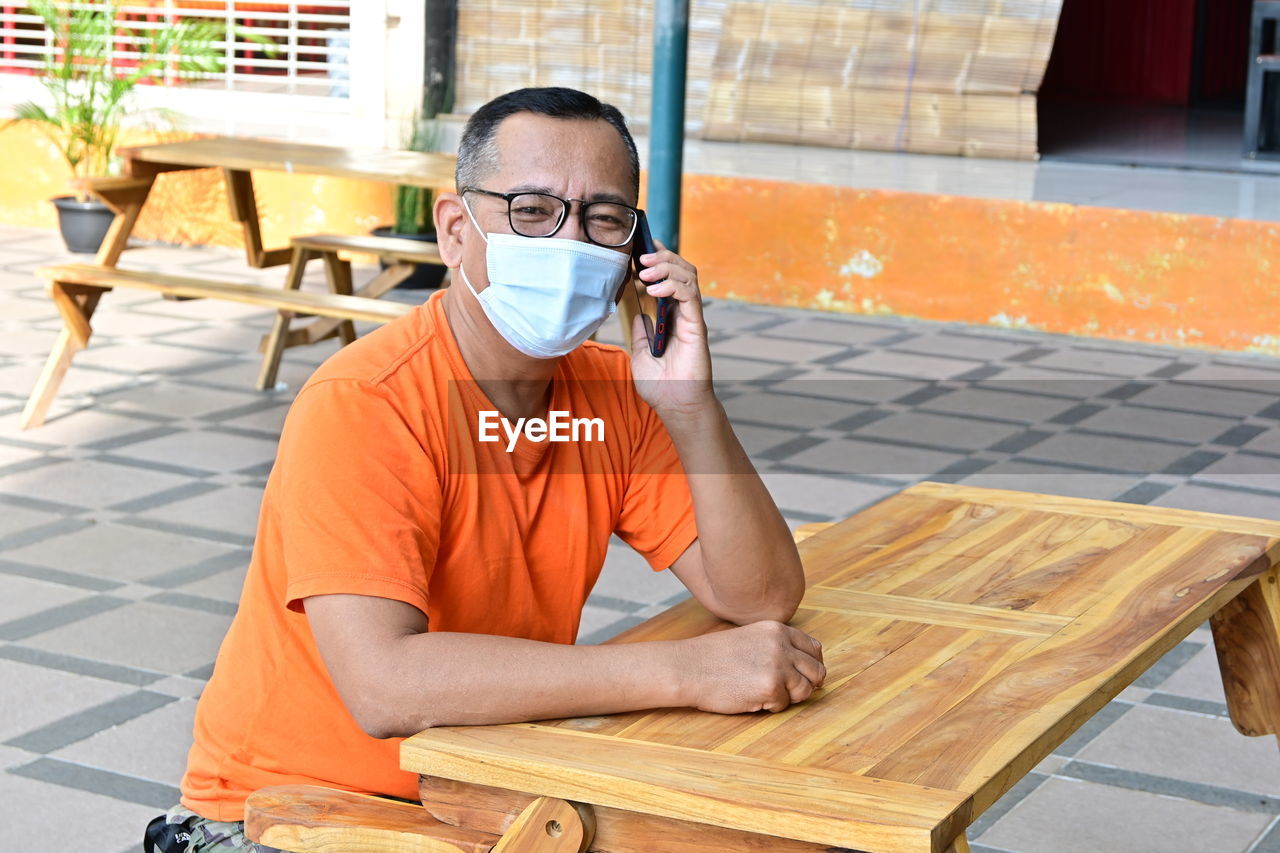 Portrait of man sitting on table