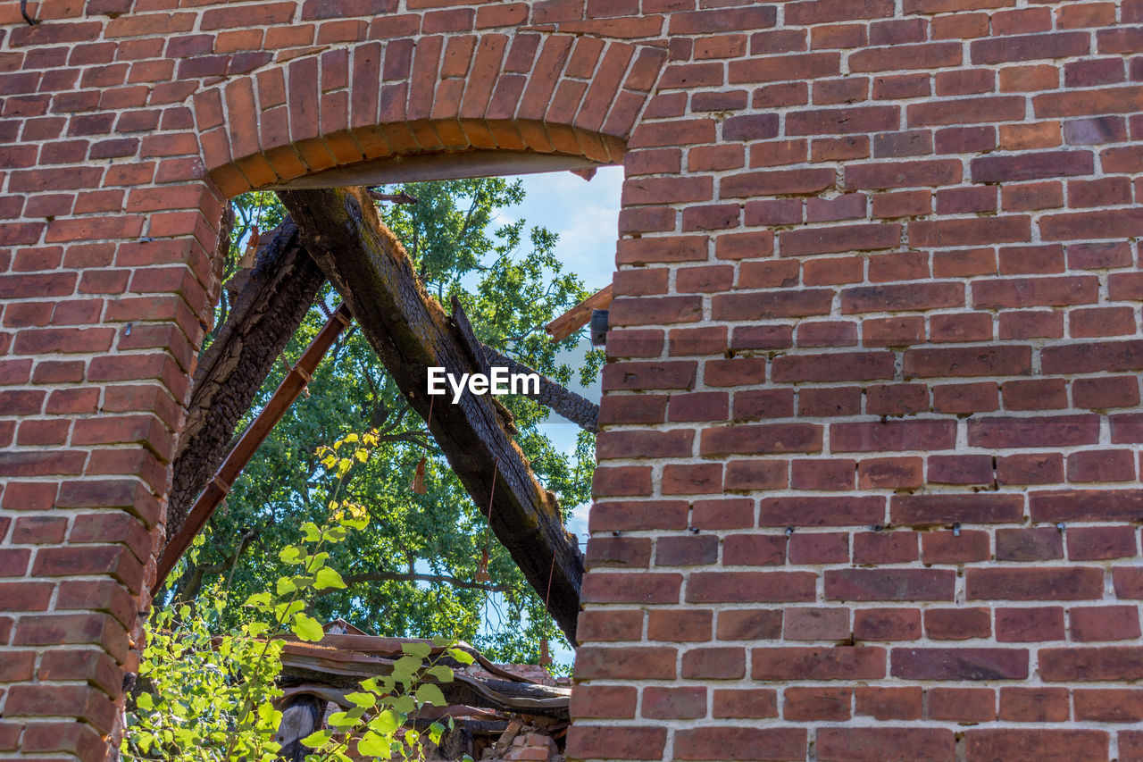 LOW ANGLE VIEW OF OLD BRICK WALL AND BUILDING