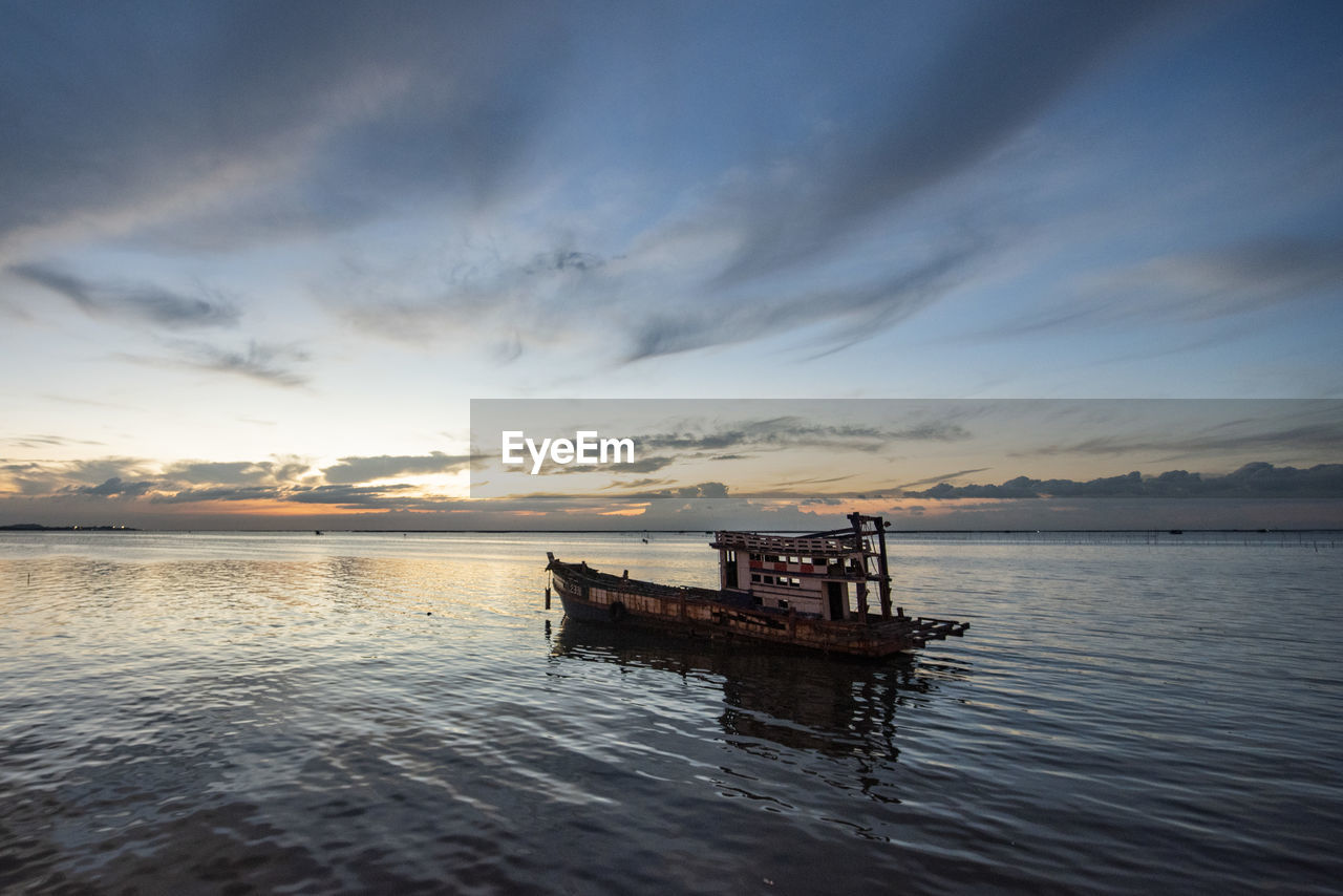 scenic view of sea against cloudy sky during sunset