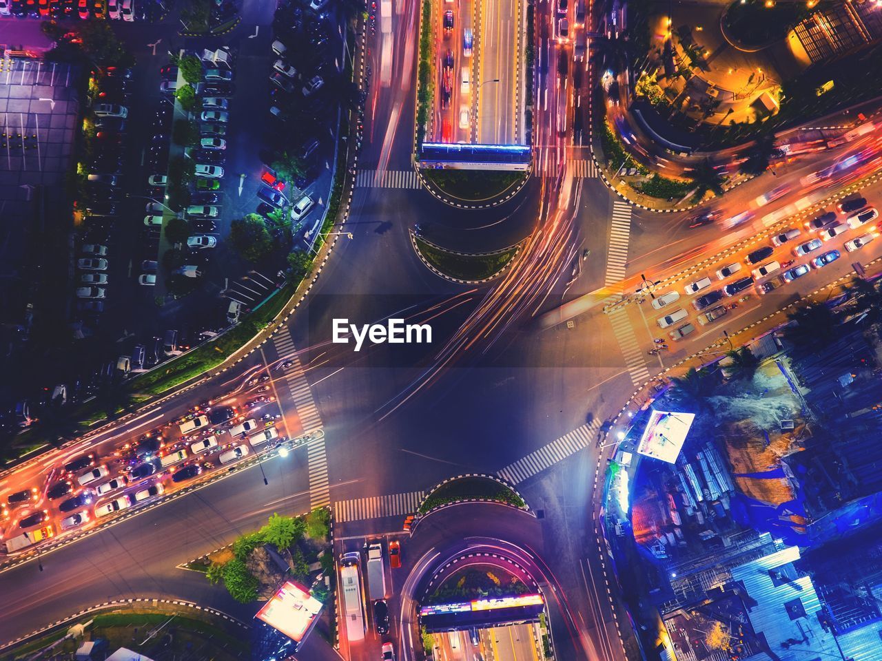 HIGH ANGLE VIEW OF ILLUMINATED STREET AMIDST BUILDINGS