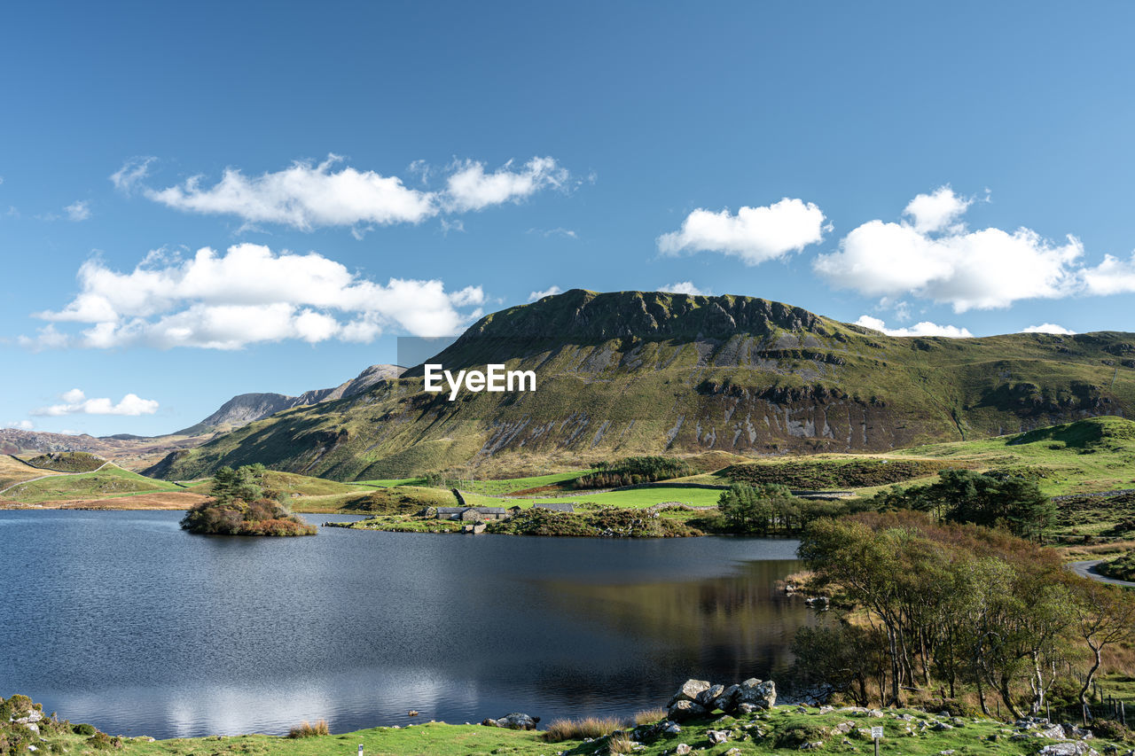 SCENIC VIEW OF LAKE BY MOUNTAIN AGAINST SKY