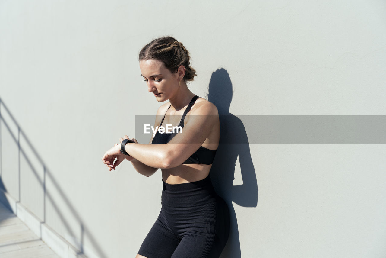 Young woman monitoring heart rate through smart watch