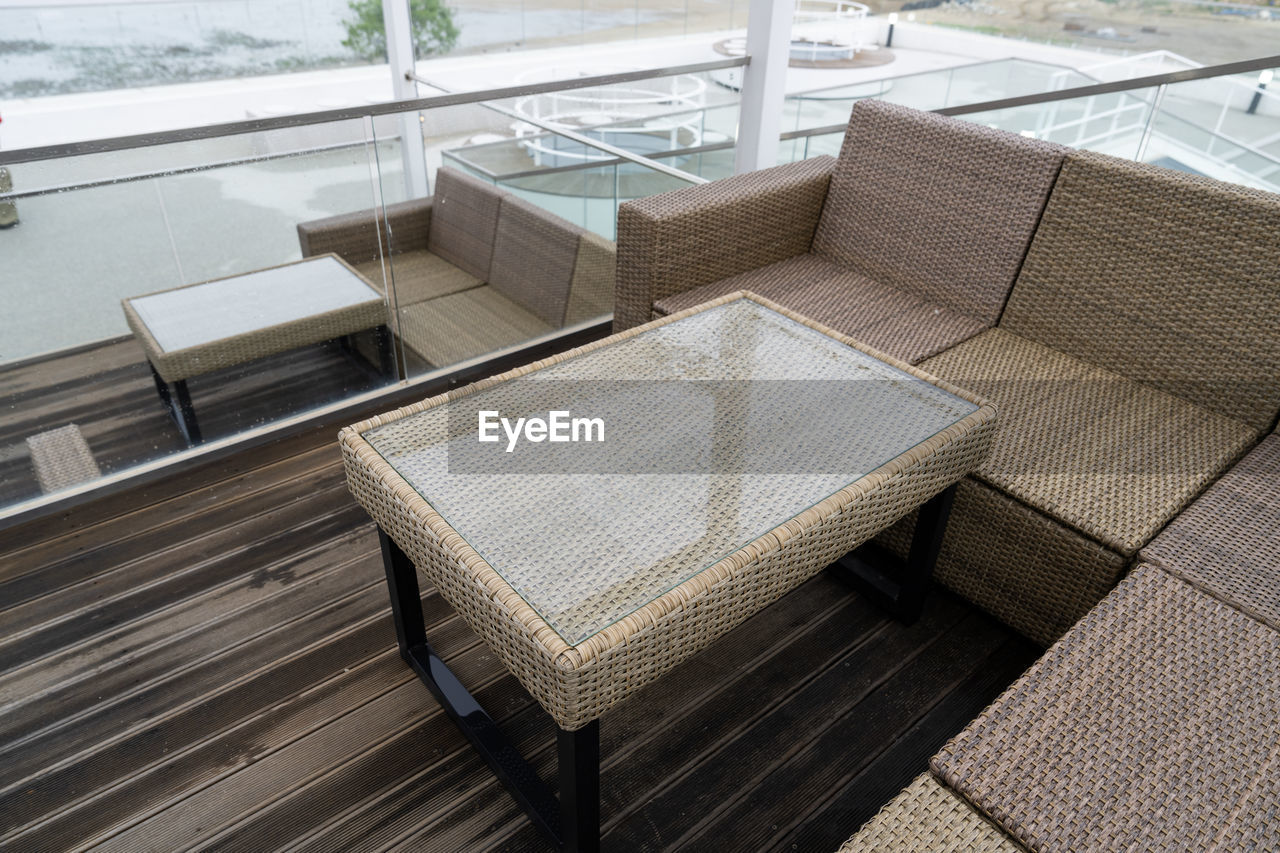 furniture, seat, architecture, chair, no people, studio couch, outdoor structure, floor, high angle view, relaxation, table, day, indoors, flooring, wicker, luxury, nature, built structure, wood, wealth, deck, sofa, home interior, water, absence, empty, couch