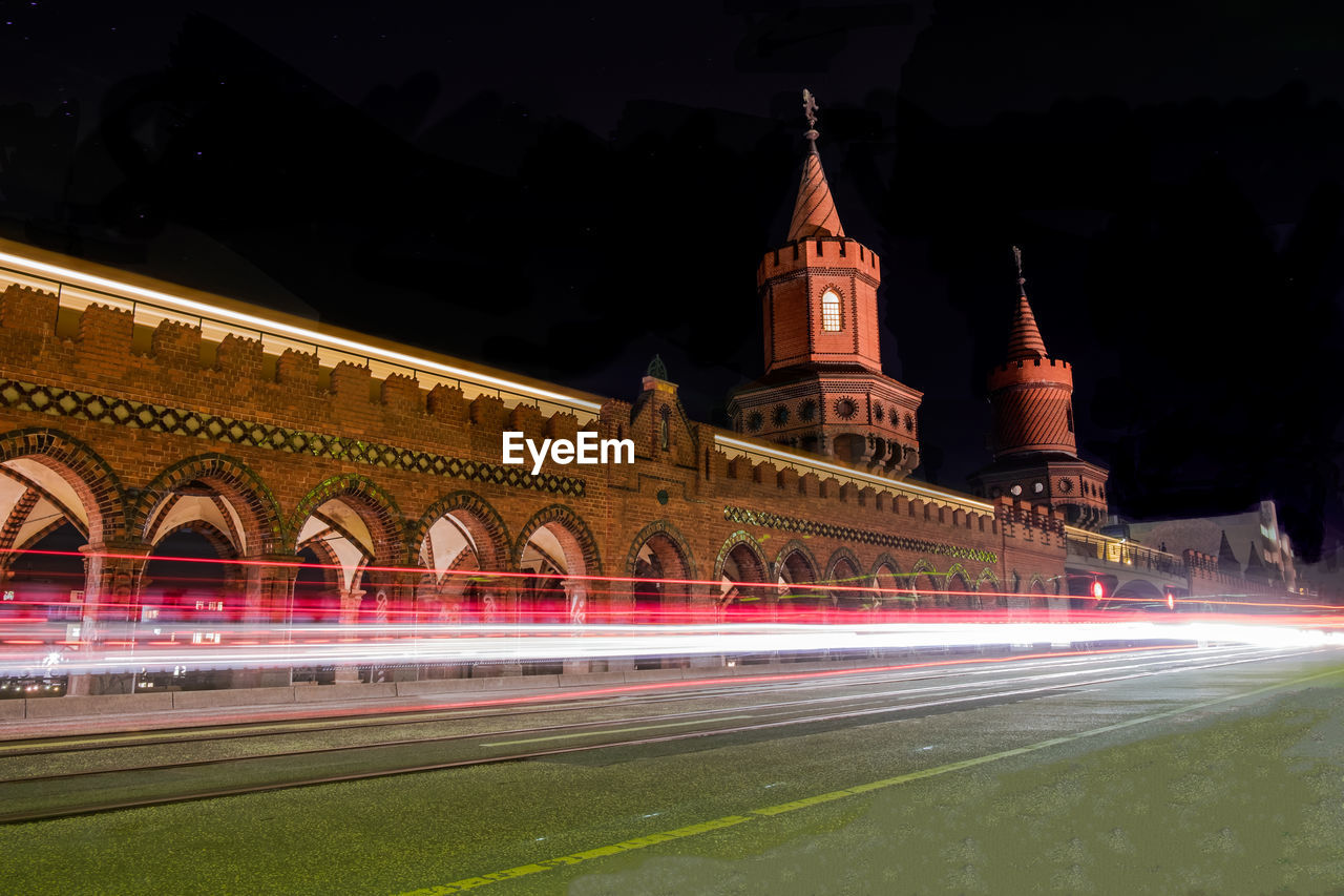 Light trails at oberbaum bridge against sky